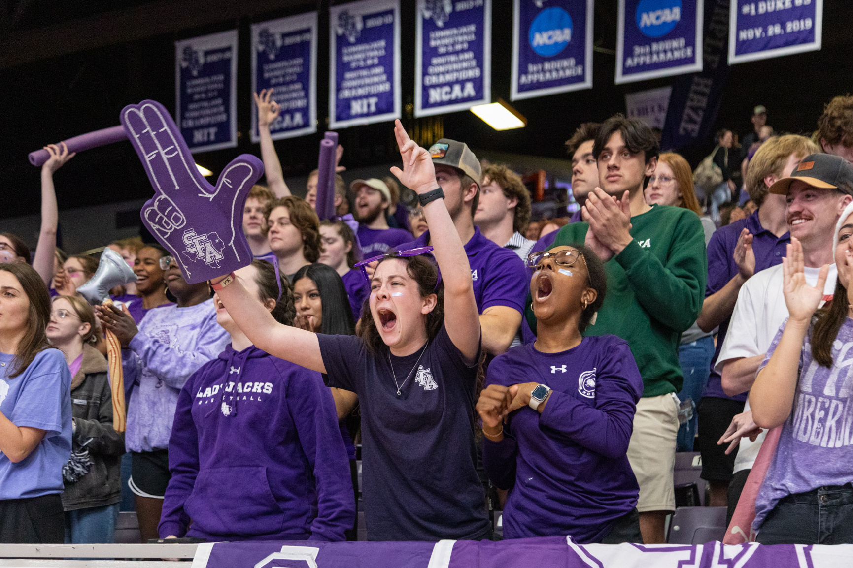 Students cheer during the first half of a basketball game against McNeese State University, inside Johnson Coliseum.