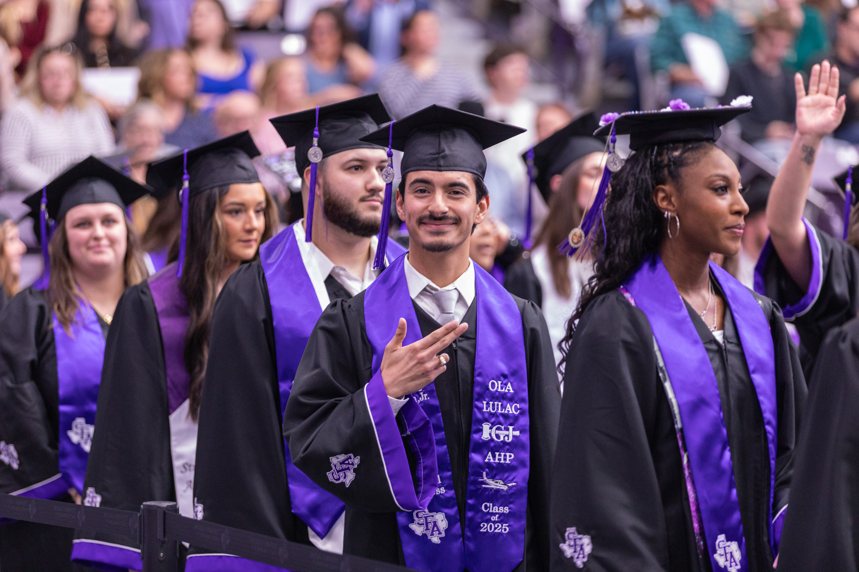 Luciano Hinojosa Jr., an Aviation Science major, gives the Axe em, Jacks hand sign during the December commencement ceremony at Stephen F. Austin State University's Johnson Coliseum.
