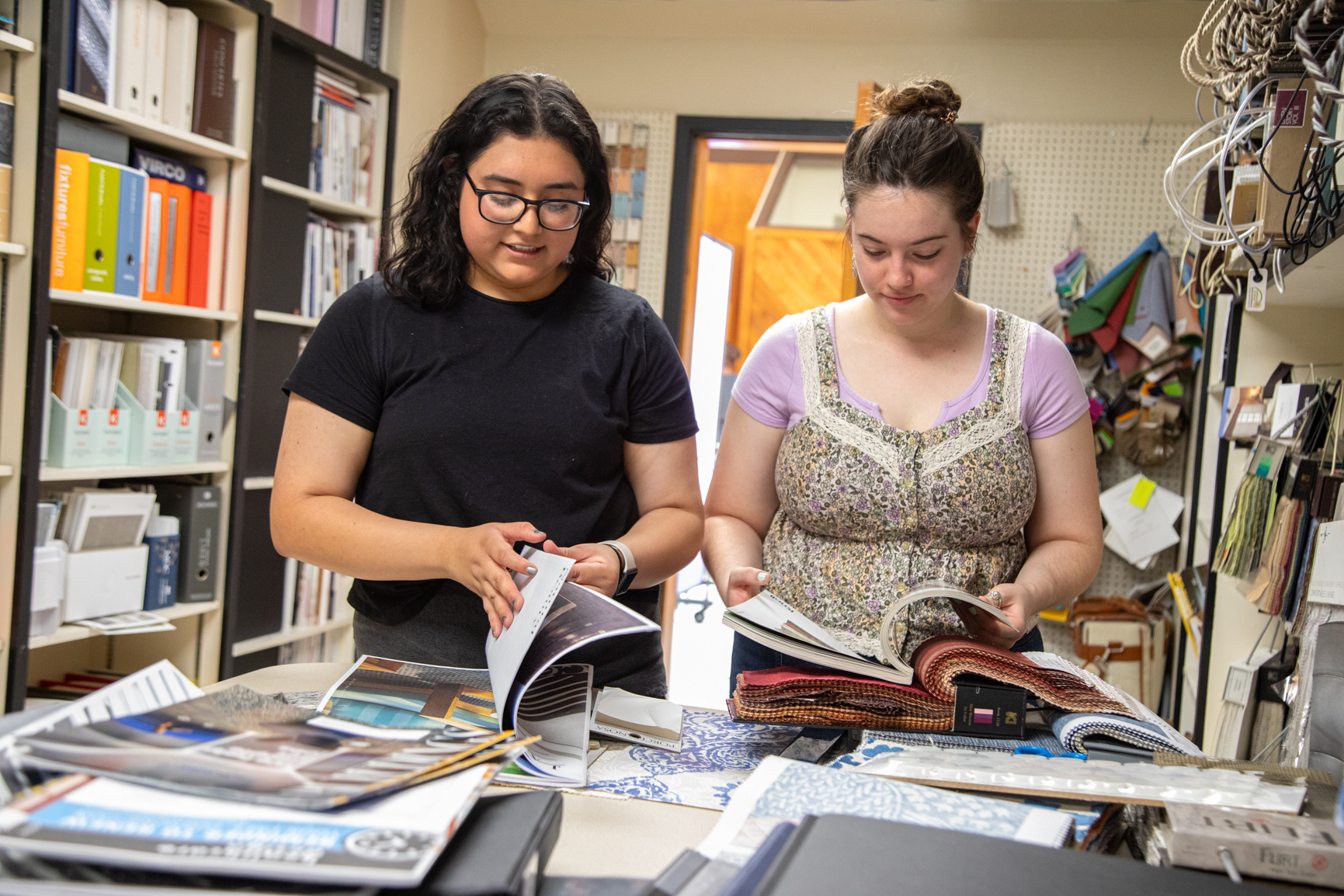 Interior design students look through materials in the Human Sciences Building South during a media production day.
