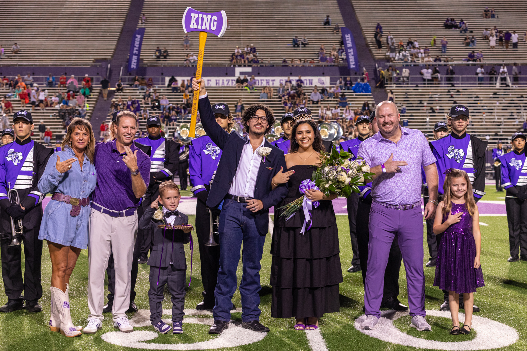 A student raises an ax after being crowned homecoming king during the homecoming football game against Nicholls State University. Series produced for Stephen F. Austin State University marketing and social media, 2025.
