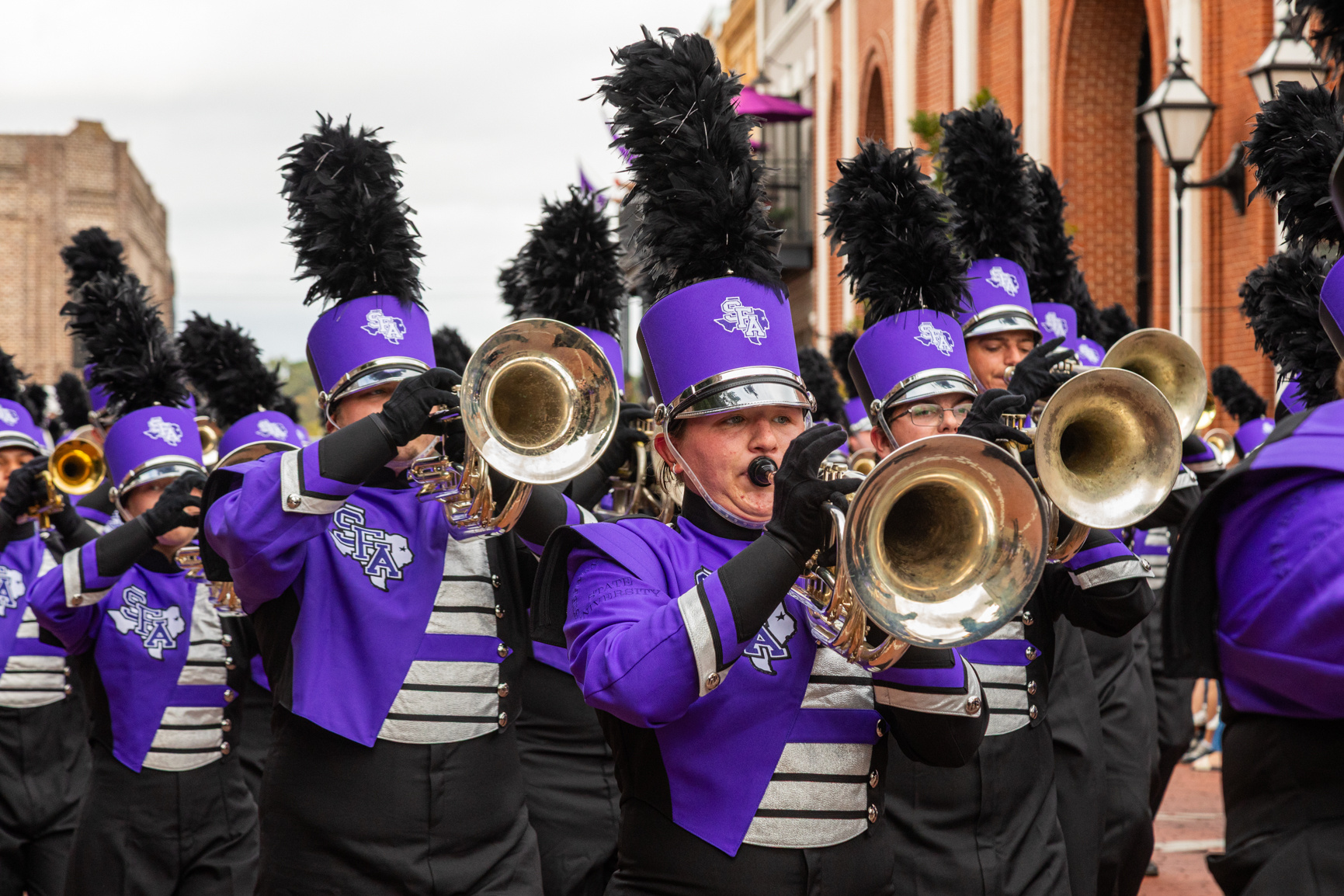 Members of the Lumberjack Marching Band march through downtown Nacogdoches during the annual SFA Homecoming parade. Series produced for Stephen F. Austin State University marketing, 2025.