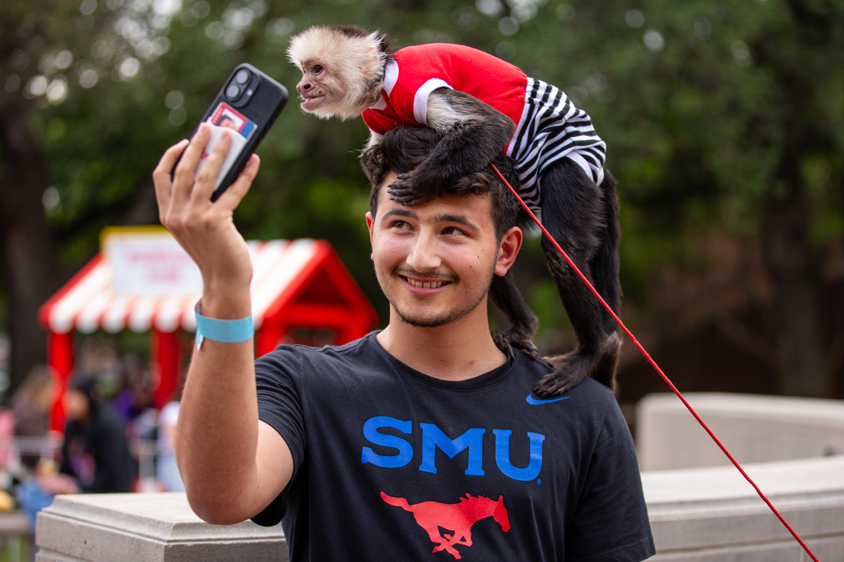 A student smiles as a monkey sits on his head during the Residents Commons Cup Competition, an annual event that brings residence hall communities together in friendly competition.